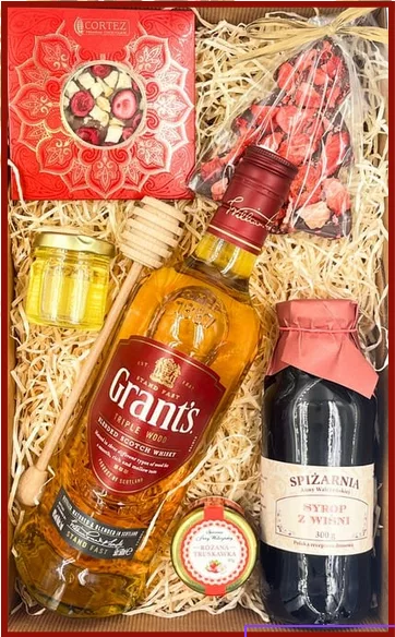 Elegancki kosz upominkowy z whisky Grant’s Triple Wood, syropem z wiśni, konfiturą i ręcznie robioną czekoladą z owocami.